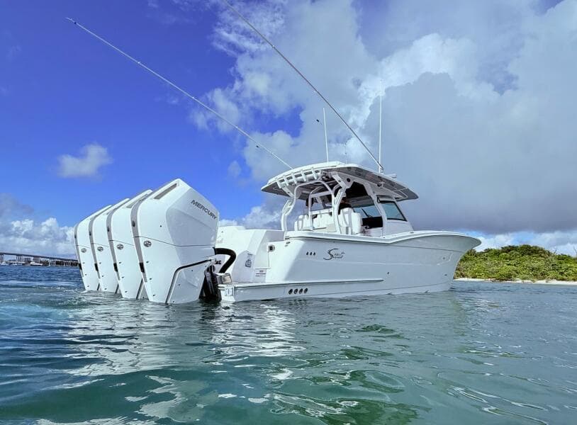 2024 Scout 400 LXF boat with multiple outboard engines on water.