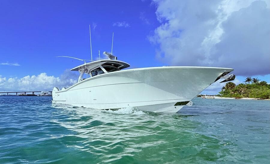 2024 Scout 400 LXF boat cruising in clear blue waters under a vibrant sky.