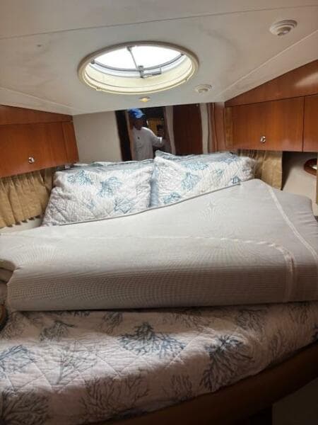 Interior of 2006 Carver 43 Motor Yacht with cozy bed and porthole window.