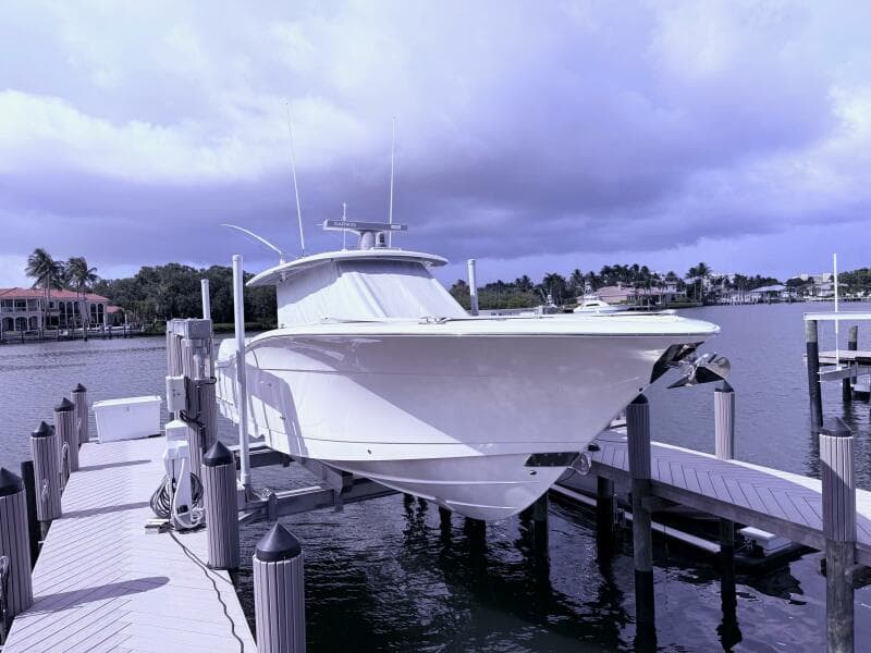2024 Scout 400 LXF boat docked at marina under cloudy sky.