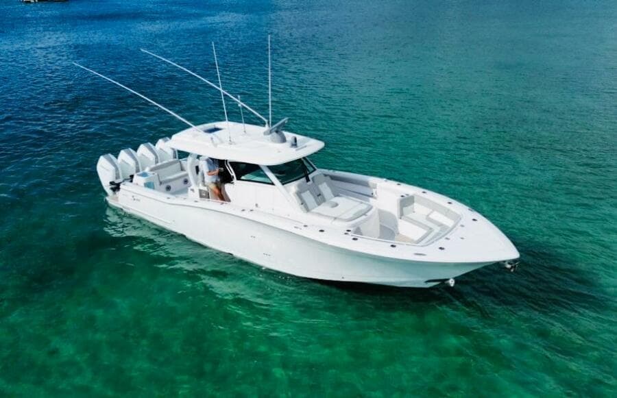 2024 Scout 400 LXF boat on clear turquoise water, showcasing sleek design and multiple engines.
