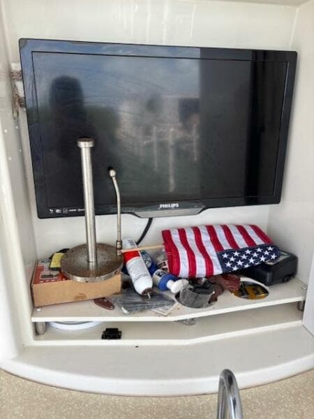 2006 Carver 43 Motor Yacht interior with TV, American flag, and assorted items on shelf.