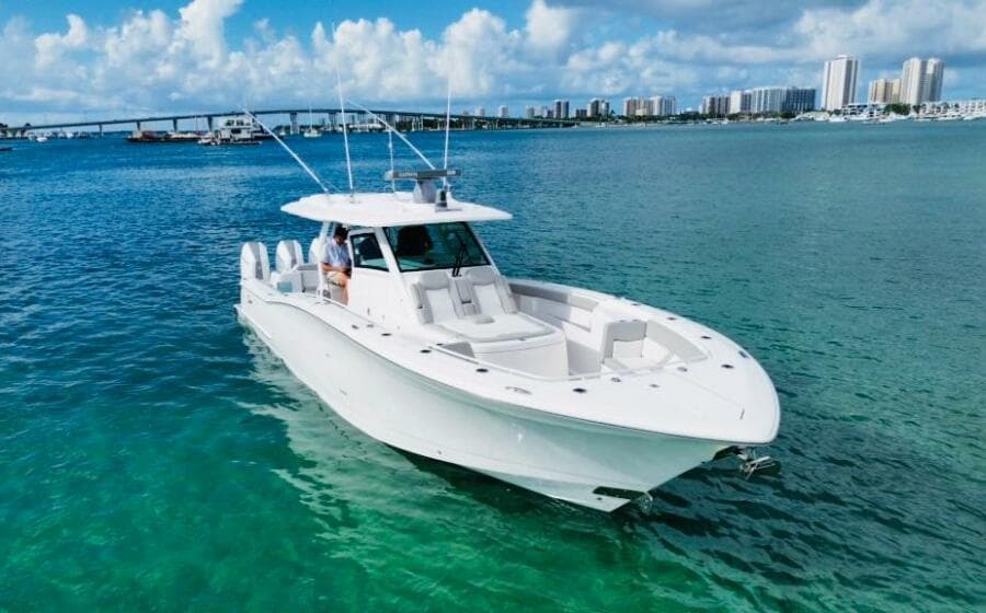 2024 Scout 400 LXF boat cruising on clear blue water near a city skyline.