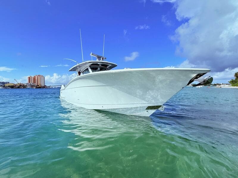 2024 Scout 400 LXF boat on clear blue water under a bright sky.