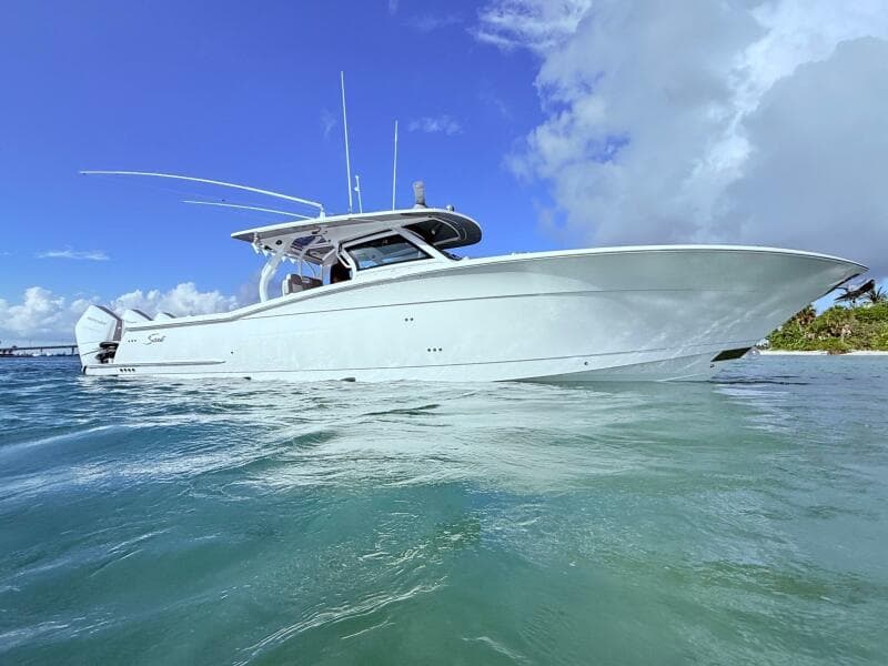 2024 Scout 400 LXF boat on clear blue water under a bright sky.