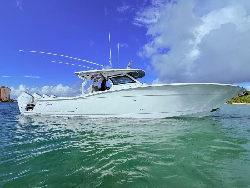 2024 Scout 400 LXF boat on clear water under a blue sky.