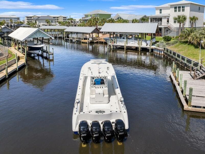 2015 Yellowfin 39 boat docked in a scenic waterfront marina with multiple outboard engines.