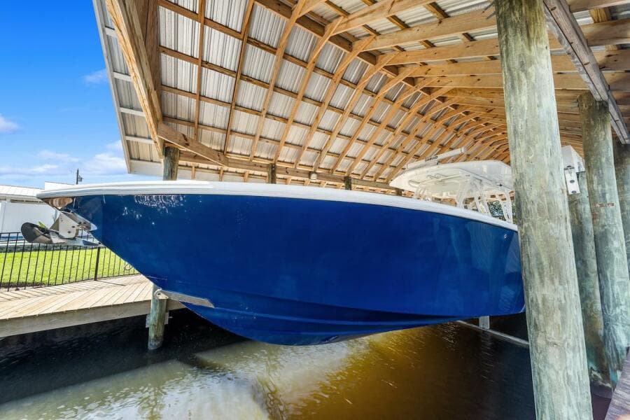 2015 Yellowfin 39 boat docked under a wooden shelter.