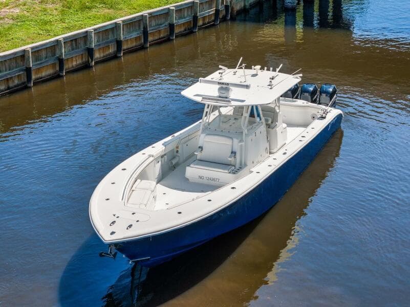2015 Yellowfin 39 boat on calm water near a wooden dock.
