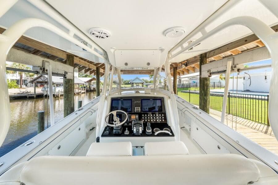 2015 Yellowfin 39 boat cockpit with advanced navigation system, docked in a serene marina setting.