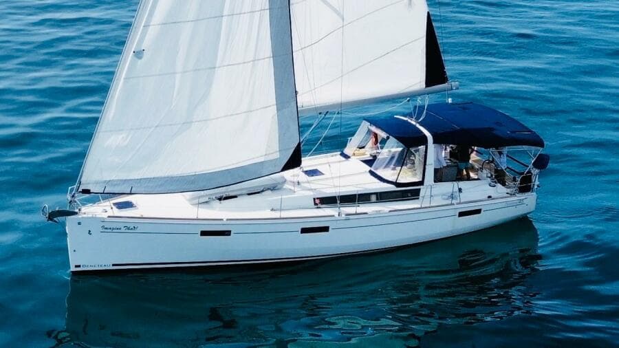 2015 Beneteau Oceanis 45 sailing yacht on calm blue waters.