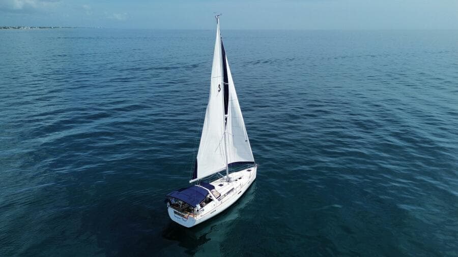 2015 Beneteau Oceanis 45 sailing on calm blue ocean waters.