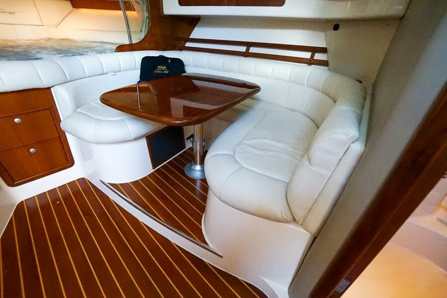 2007 Grady-White Express 360 interior with white leather seating and wooden table.