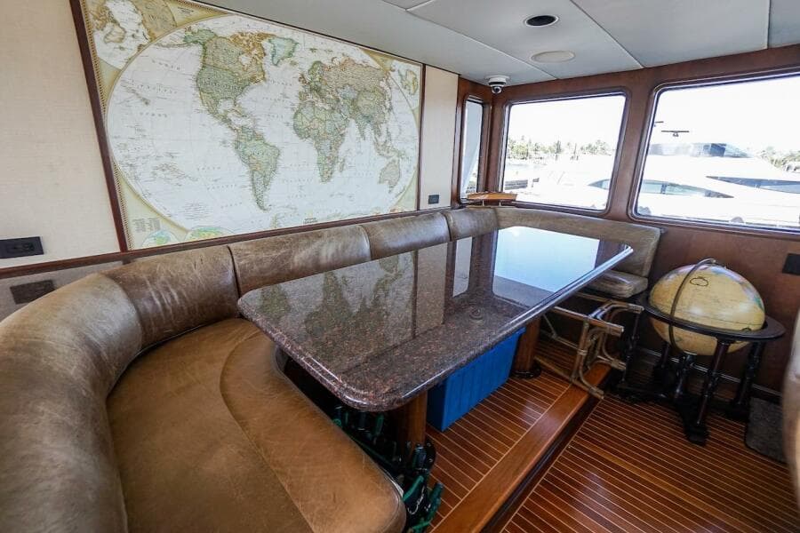 Luxury yacht deck with three white chairs, overlooking marina and waterfront buildings. ABD 90 Explorer, 1996.