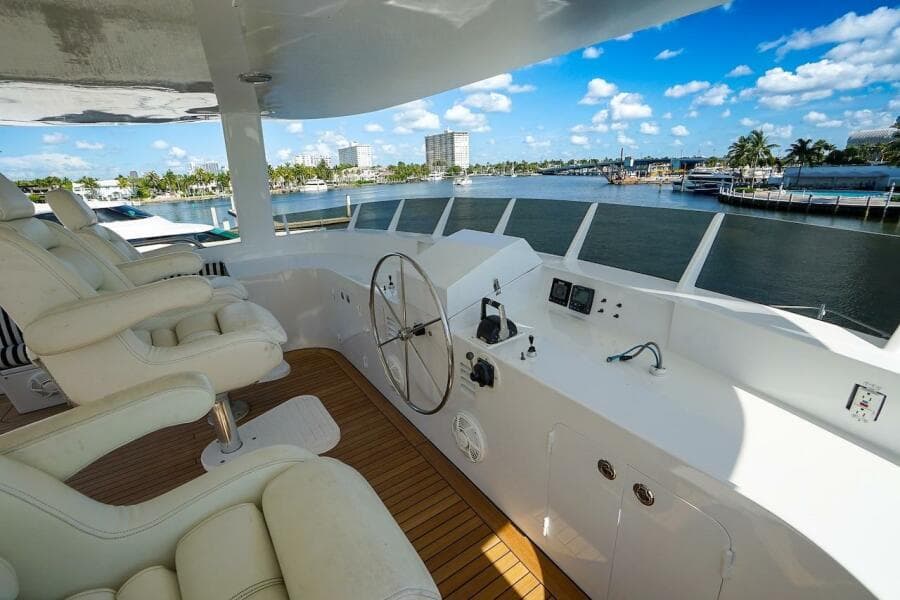 Luxurious 1996 ABD 90 Explorer yacht deck with striped seating and polished wooden table.
