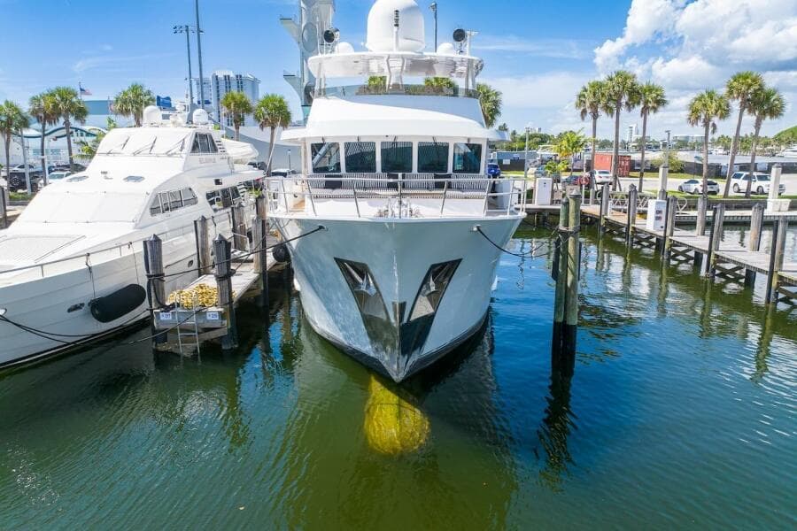 Luxury yacht ABD 90 Explorer 1996 docked at marina, surrounded by palm trees and clear skies.