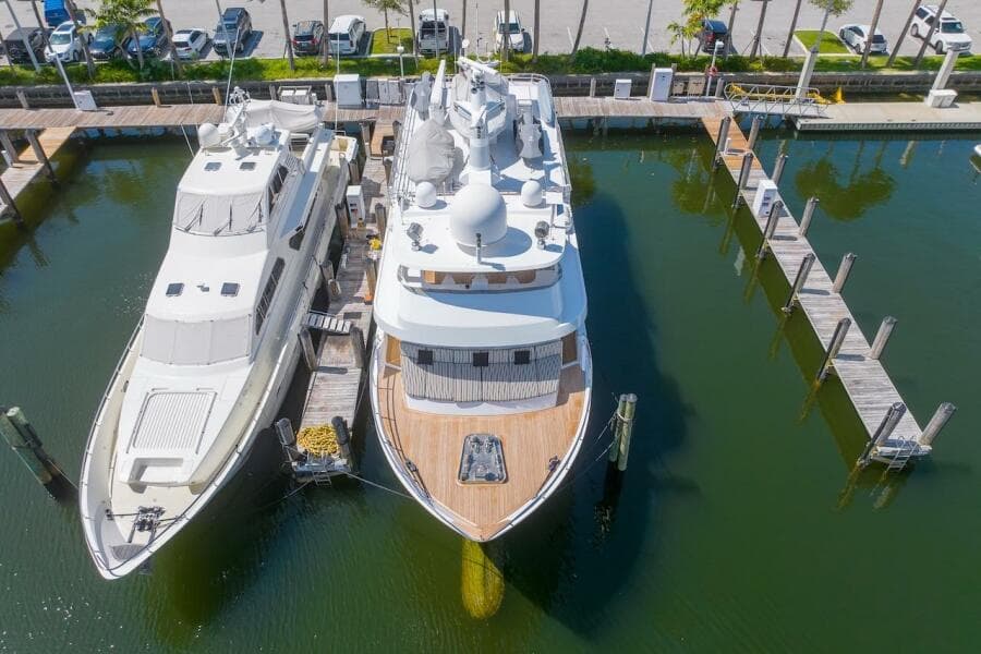 Two luxury yachts docked at a marina, featuring the 1996 ABD 90 Explorer.