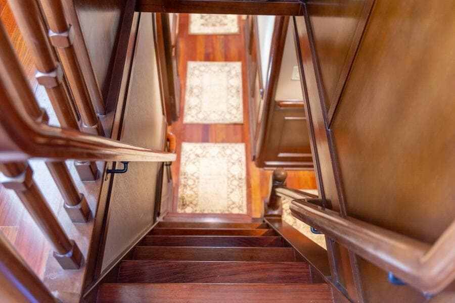 Luxurious deck of 1996 ABD 90 Explorer yacht with wooden furniture and striped cushions.