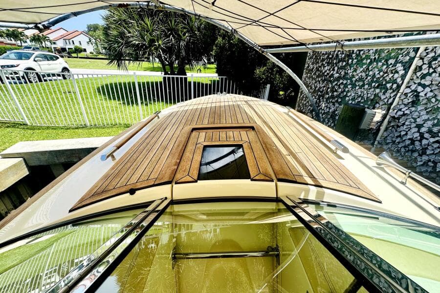 2013 Chris-Craft Corsair 22 boat with wooden deck, parked under a canopy.