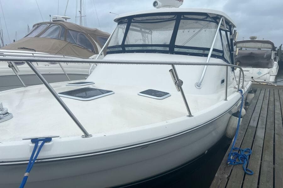 2001 Pursuit 3000 Offshore boat docked at marina, featuring sleek design and spacious deck.