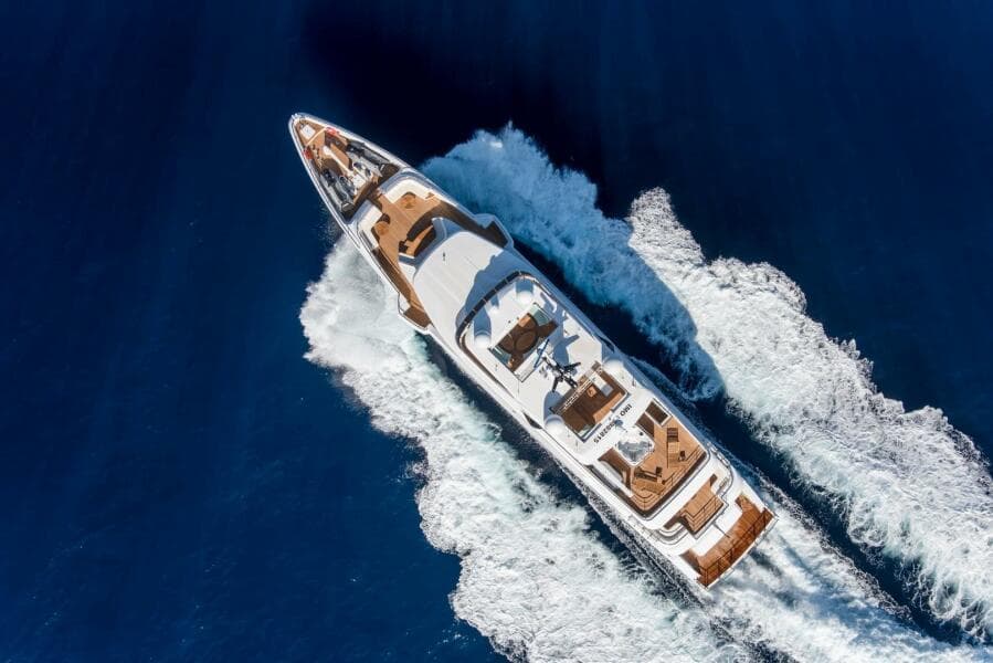 Aerial view of 2020 Majesty 140 yacht cruising on blue ocean waters.