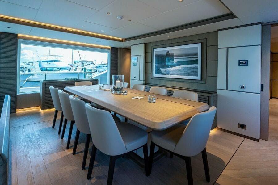 Luxurious dining area on 2020 Majesty 140 yacht with elegant decor and marina view.