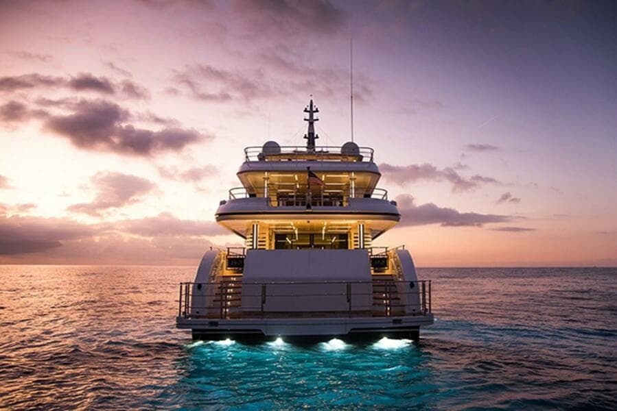 Majesty 140 yacht at sunset, 2020 model, illuminated on calm ocean waters.