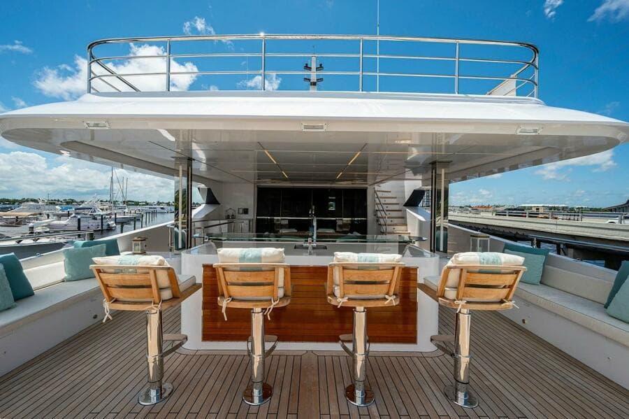 Luxury Majesty 140 yacht deck with bar stools, 2020 model, under clear blue sky.