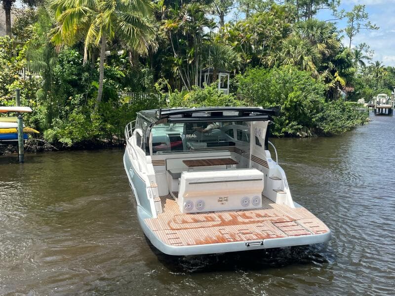 Luxury 2025 Real 40 HT boat on a serene river, surrounded by lush greenery.