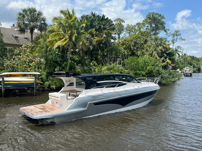 2025 Real 40 HT Luxury yacht cruising on a scenic river with lush greenery.