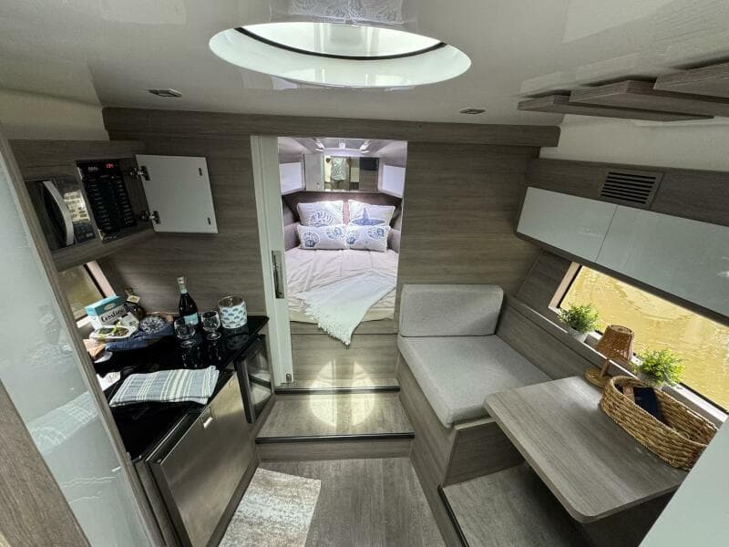 Luxurious interior of 2025 Real 40 HT yacht, featuring modern kitchen and cozy bedroom.