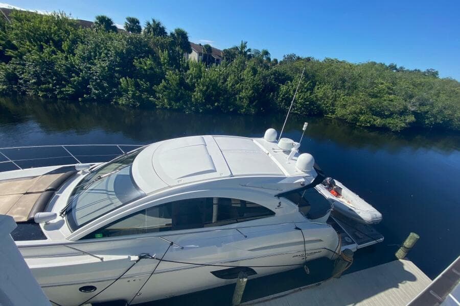 2014 Beneteau Gran Turismo 44 yacht docked by a lush riverside.