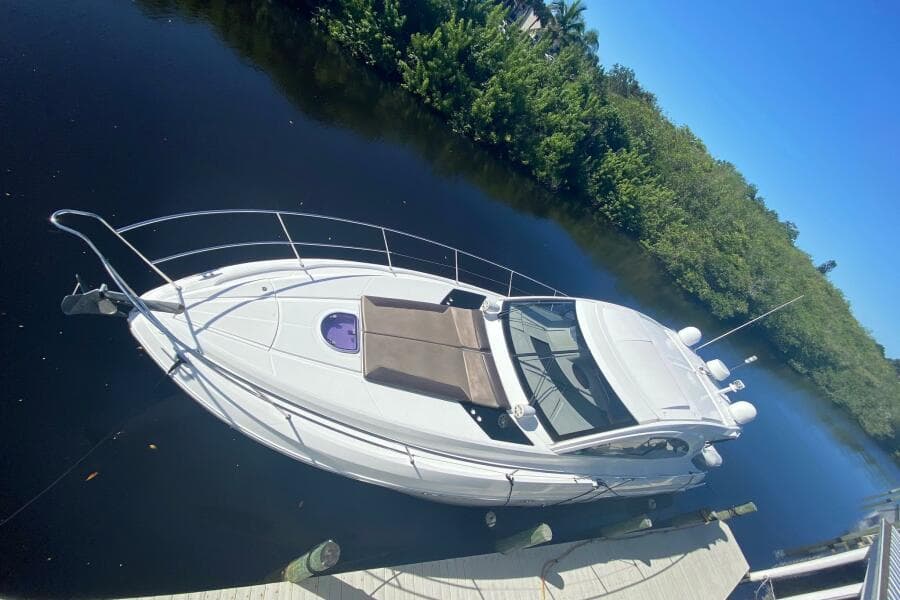 2014 Beneteau Gran Turismo 44 yacht docked on calm water, surrounded by lush greenery.