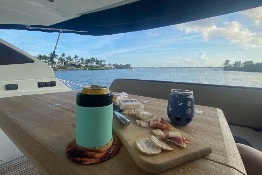 Luxurious 2014 Beneteau Gran Turismo 44 yacht with scenic waterfront view and charcuterie board.