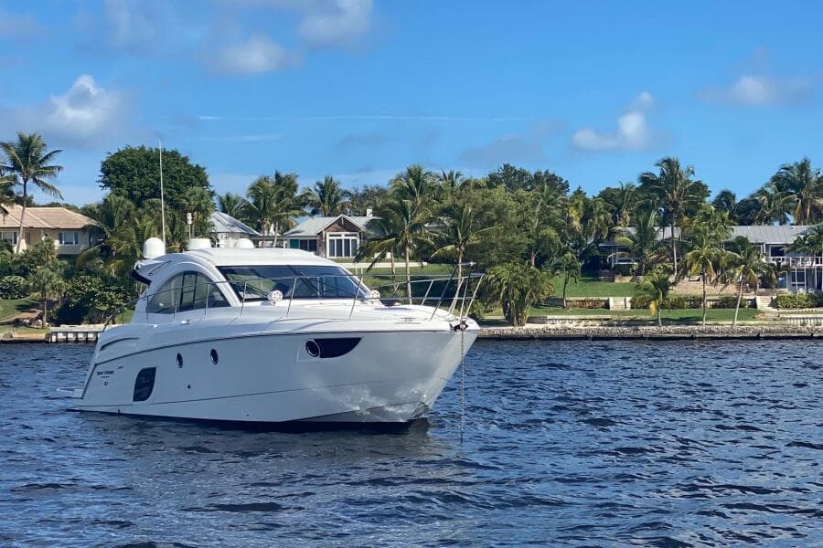 2014 Beneteau Gran Turismo 44 yacht on a sunny day, near a tropical shoreline.