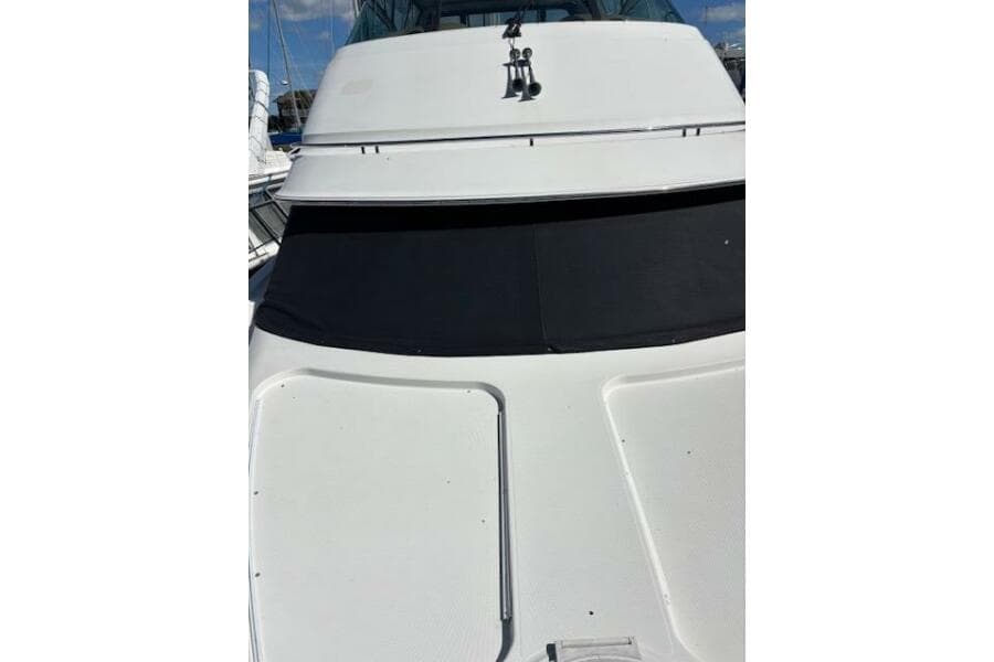 2004 Carver 466 Motor Yacht with sleek white exterior and tinted windows.
