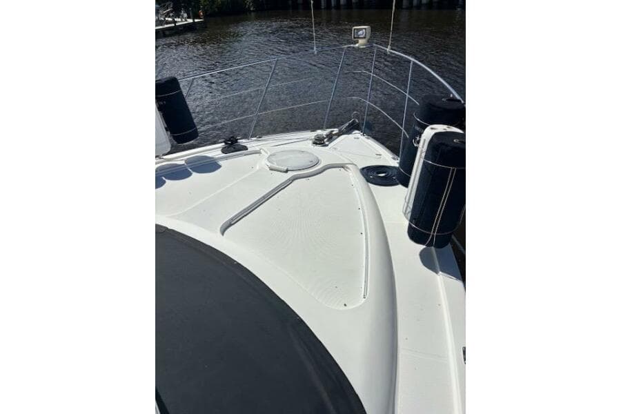 2004 Carver 466 Motor Yacht deck with railing and fenders on a sunny day.