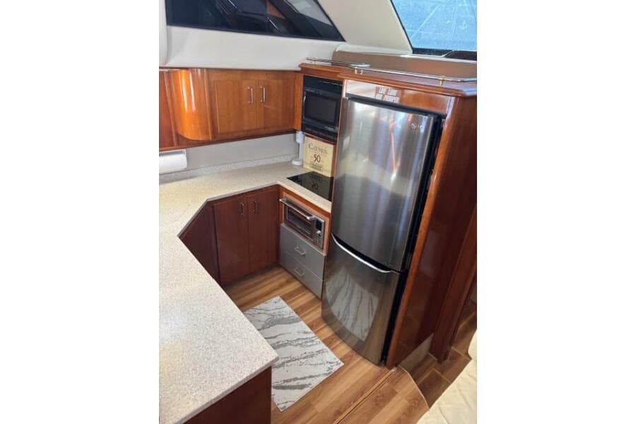 2004 Carver 466 Motor Yacht kitchen with wood cabinetry and stainless steel appliances.