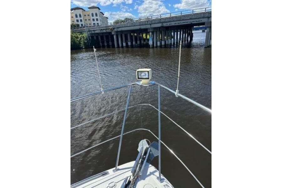 Bow view of 2004 Carver 466 Motor Yacht approaching a bridge on a sunny day.