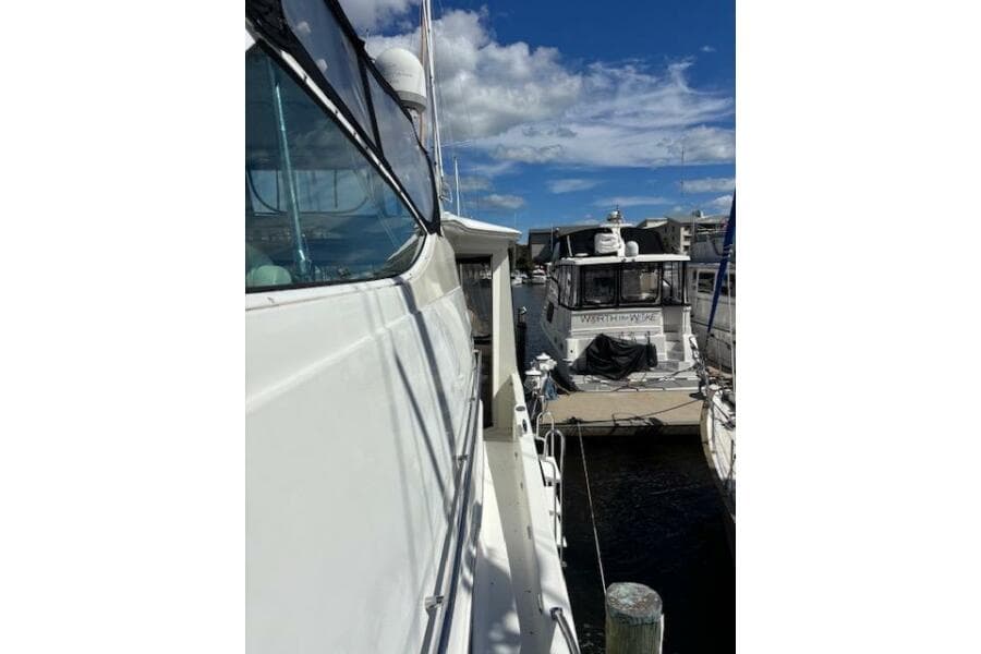 2004 Carver 466 Motor Yacht docked at marina under blue sky.