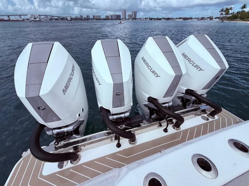 Four Mercury outboard engines on a 2024 Scout 400 LXF boat, ocean backdrop.