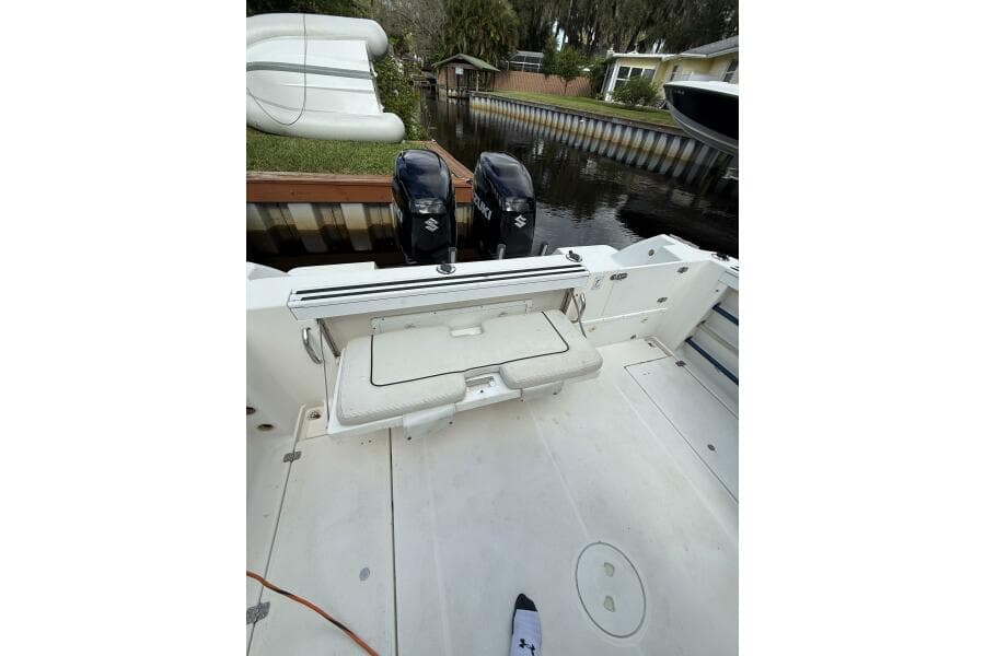 2002 Wellcraft 290 Coastal boat interior with dual outboard motors, docked by a canal.