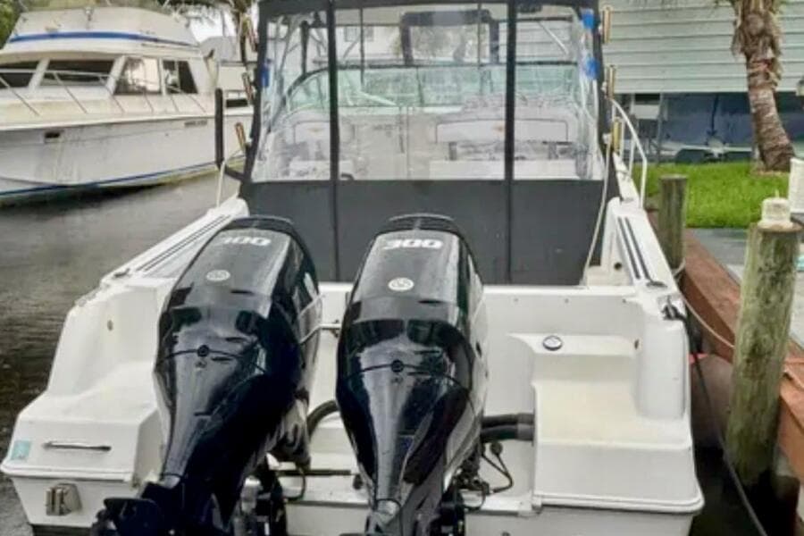 2002 Wellcraft 290 Coastal boat with dual outboard engines docked at marina.