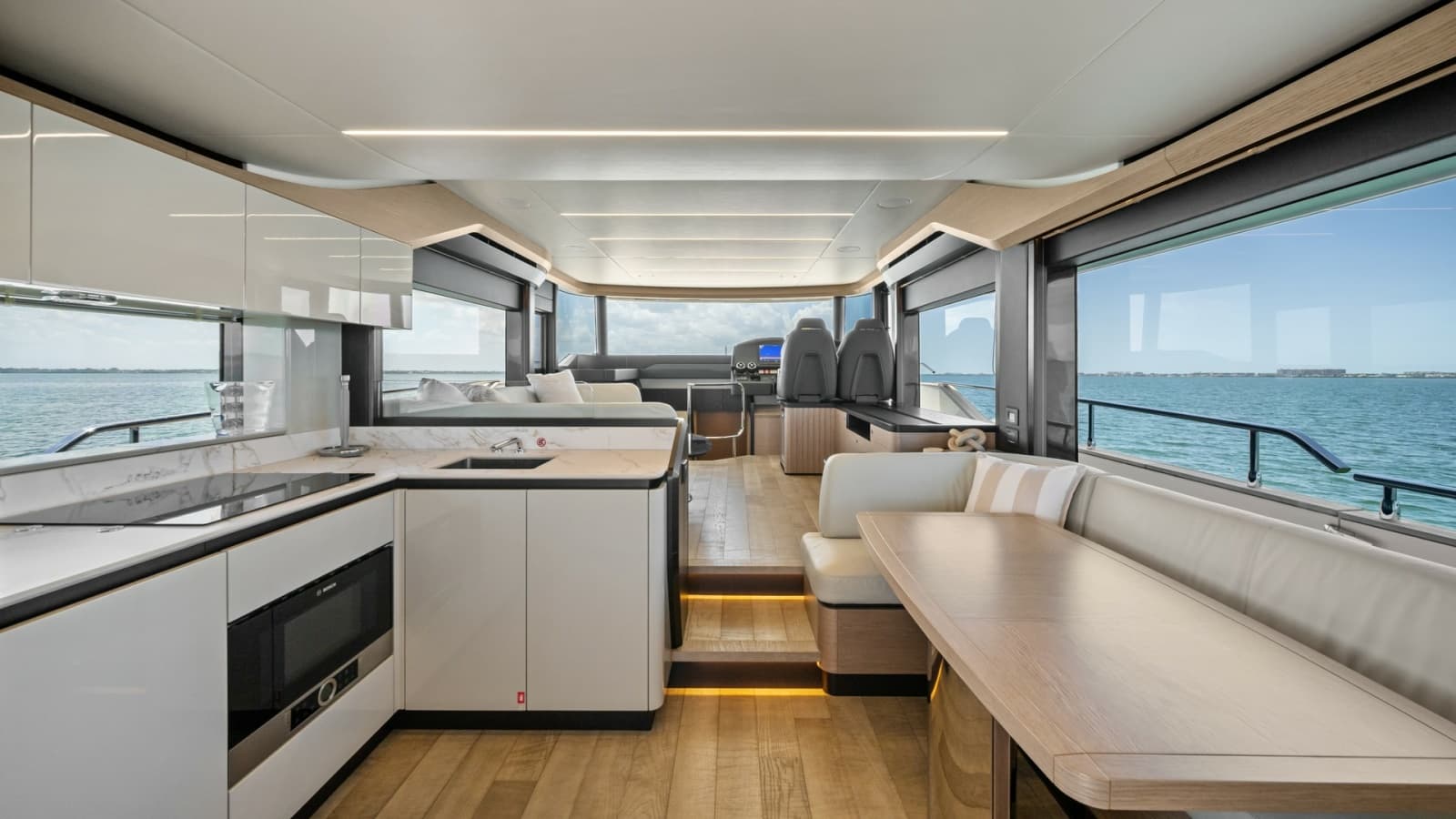 2026 Absolute Navetta 58 "ANDIAMO" Offers a Luxurious and Cozy Interior Salon That Features High-End Finishes, Including Sleek Cabinetry and Elegant Wood Flooring, Complemented by Comfortable Seating and a Stylish Dining Area.